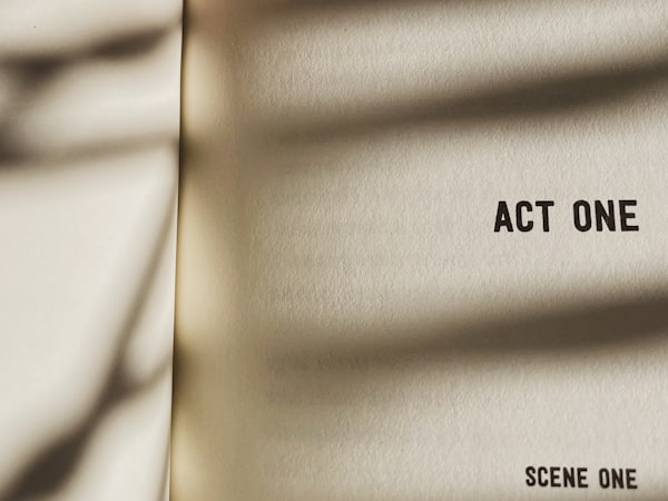 A close up of a piece of paper. It reads, "Act One: Scene One"