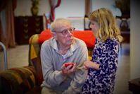 man in gray sweater sitting beside woman in black and white floral long sleeve shirt