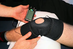 Close-up of hands adjusting a patient's therapy device during treatment