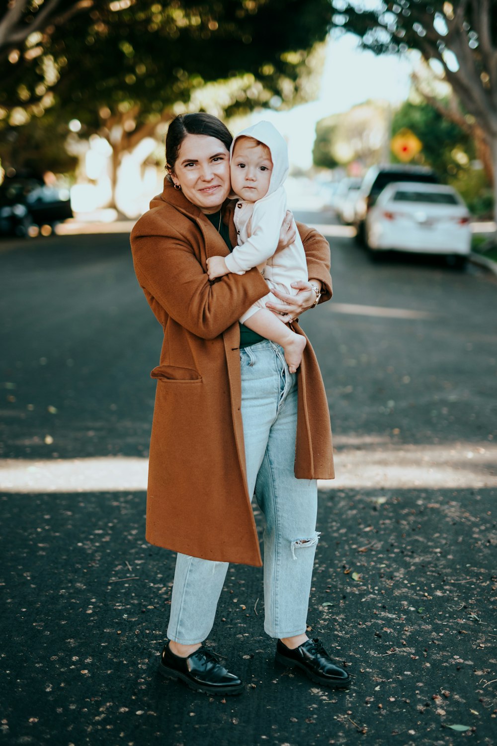 woman in brown coat standing on road during daytime