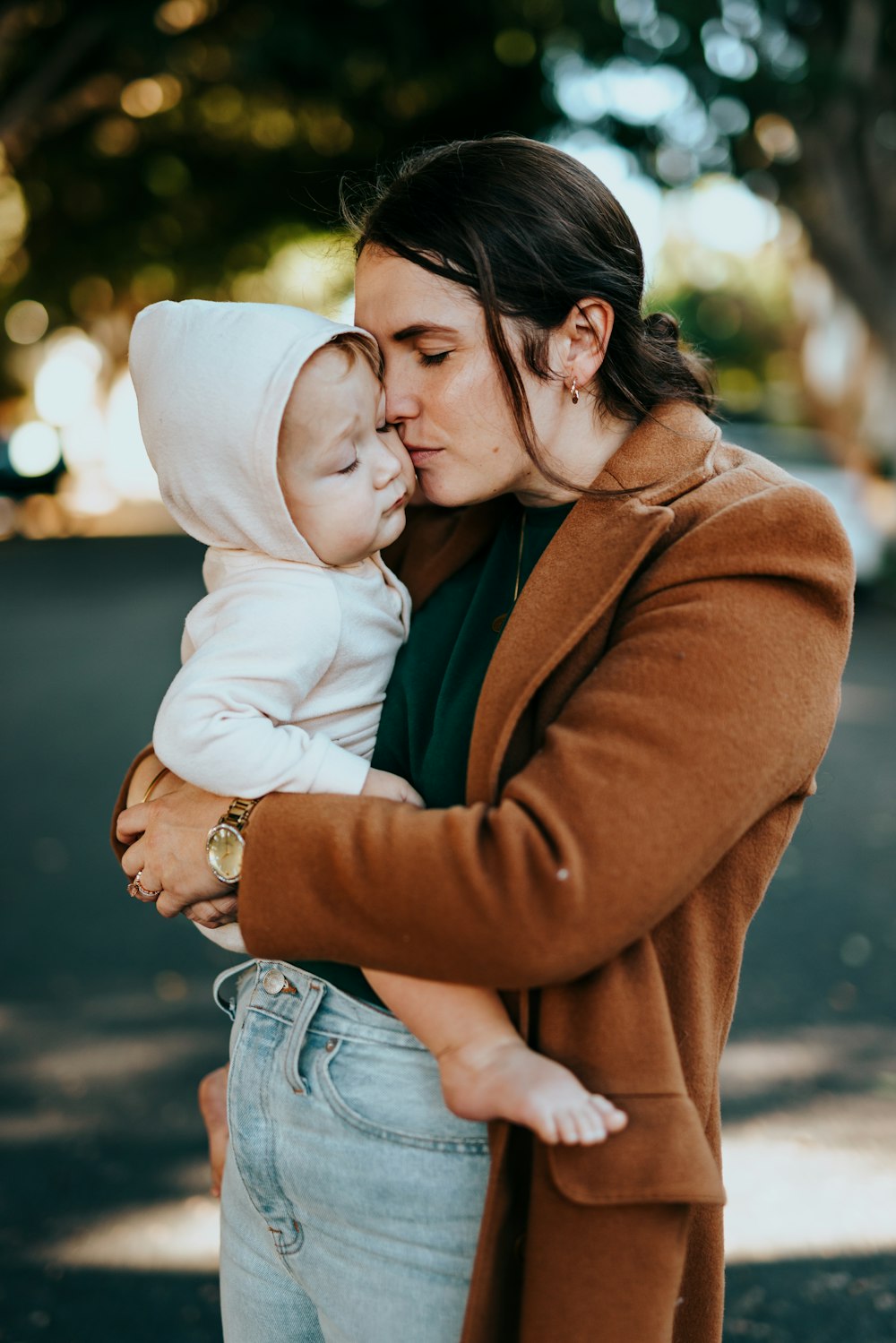 woman in brown coat hugging woman in white knit cap