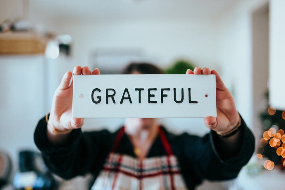 person holding "grateful" card