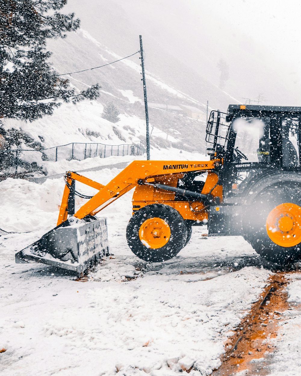 yellow and black heavy equipment on snow covered ground during daytime