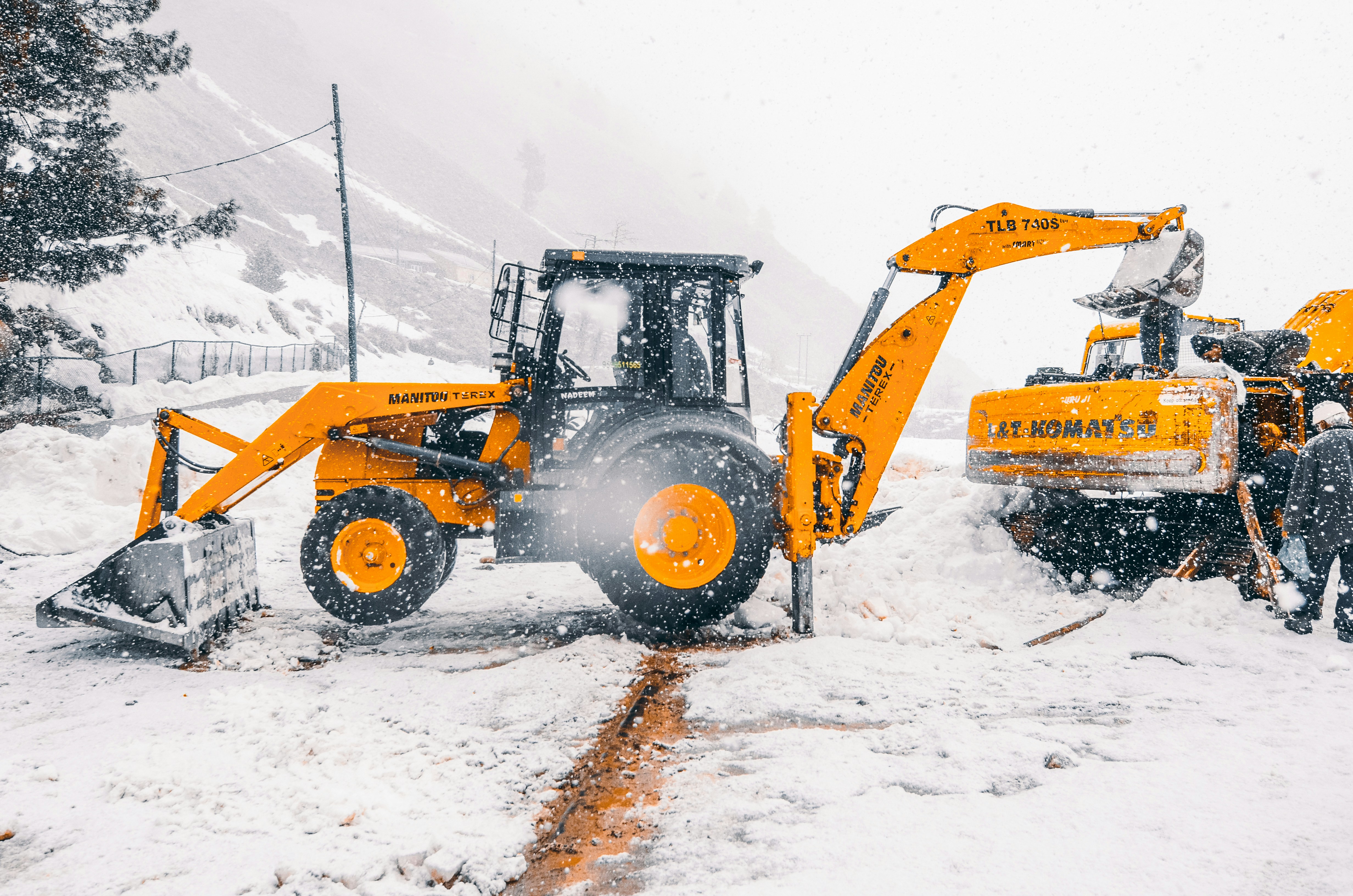 yellow and black heavy equipment on snow covered ground during daytime