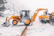 Crew members operating heavy equipment to clear snow from a rural driveway.