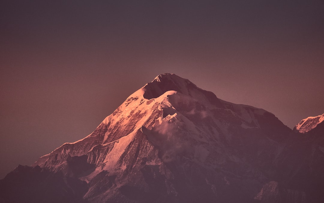 brown and white mountain under gray sky