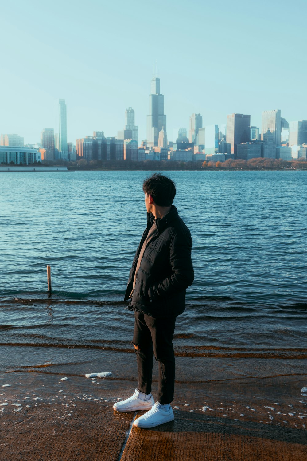 man in black jacket standing on dock during daytime