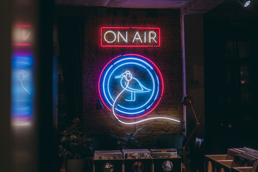 a neon sign that reads on air on a brick wall