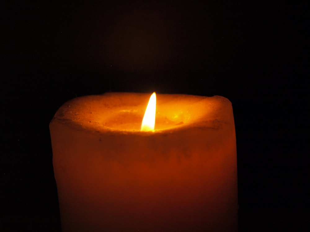 lighted candle in dark room