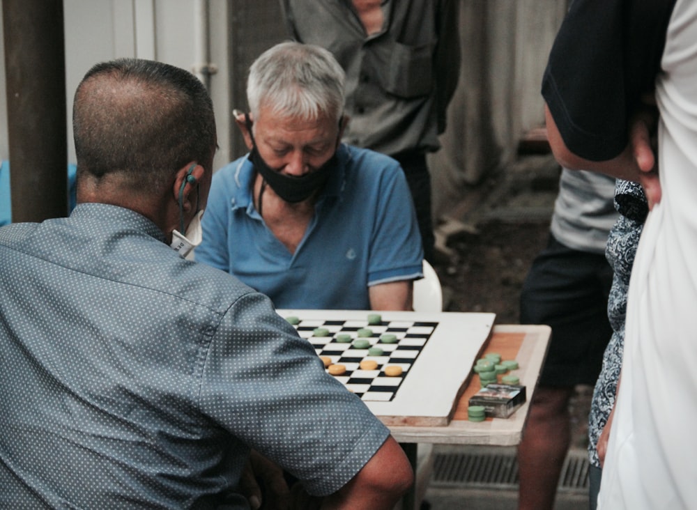 チェスをする青いポロシャツを着た男