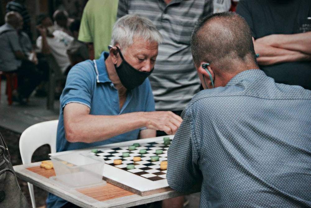 man in blue t-shirt playing chess