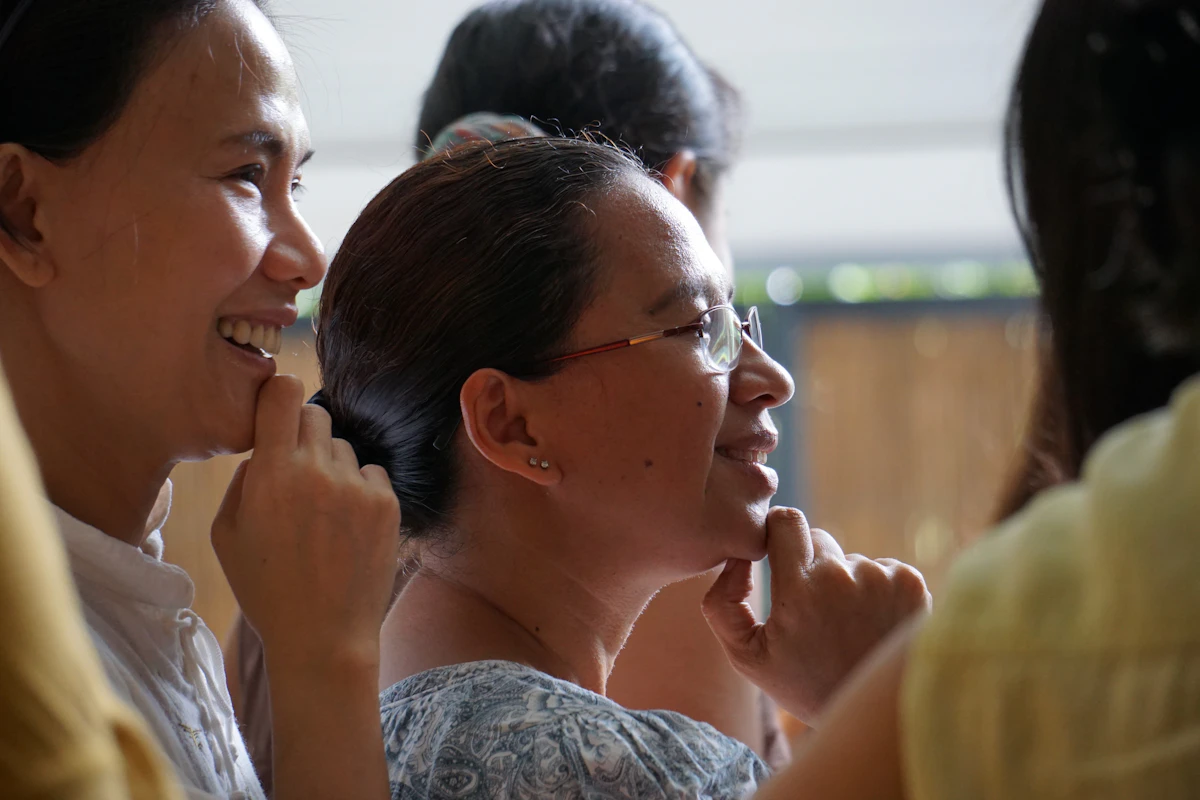 A smiling woman in a white shirt and eyeglasses