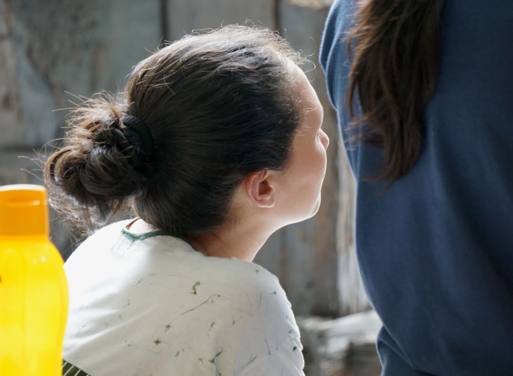 woman in white shirt standing beside woman in blue shirt