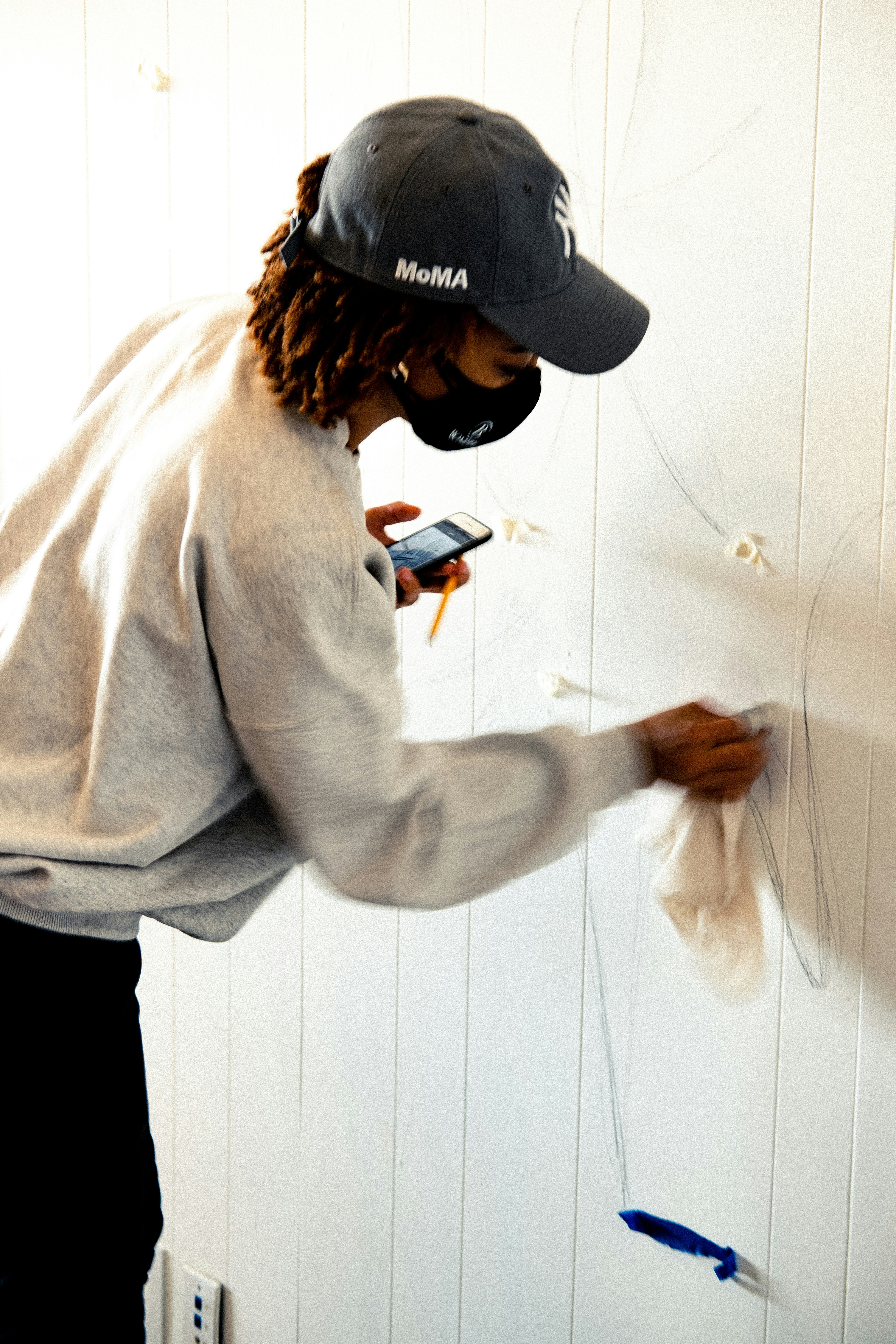 Person wiping wall surface clean with cloth before repair