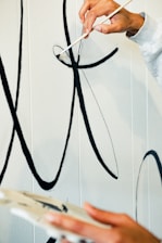 A painter carefully applying a smooth coat of paint on a modern apartment wall in Abu Dhabi.