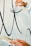 A person is painting large black calligraphic strokes on a light-colored wall. The hand holding the brush is steady and focused on creating smooth, flowing lines, while the other hand appears to be holding a palette.