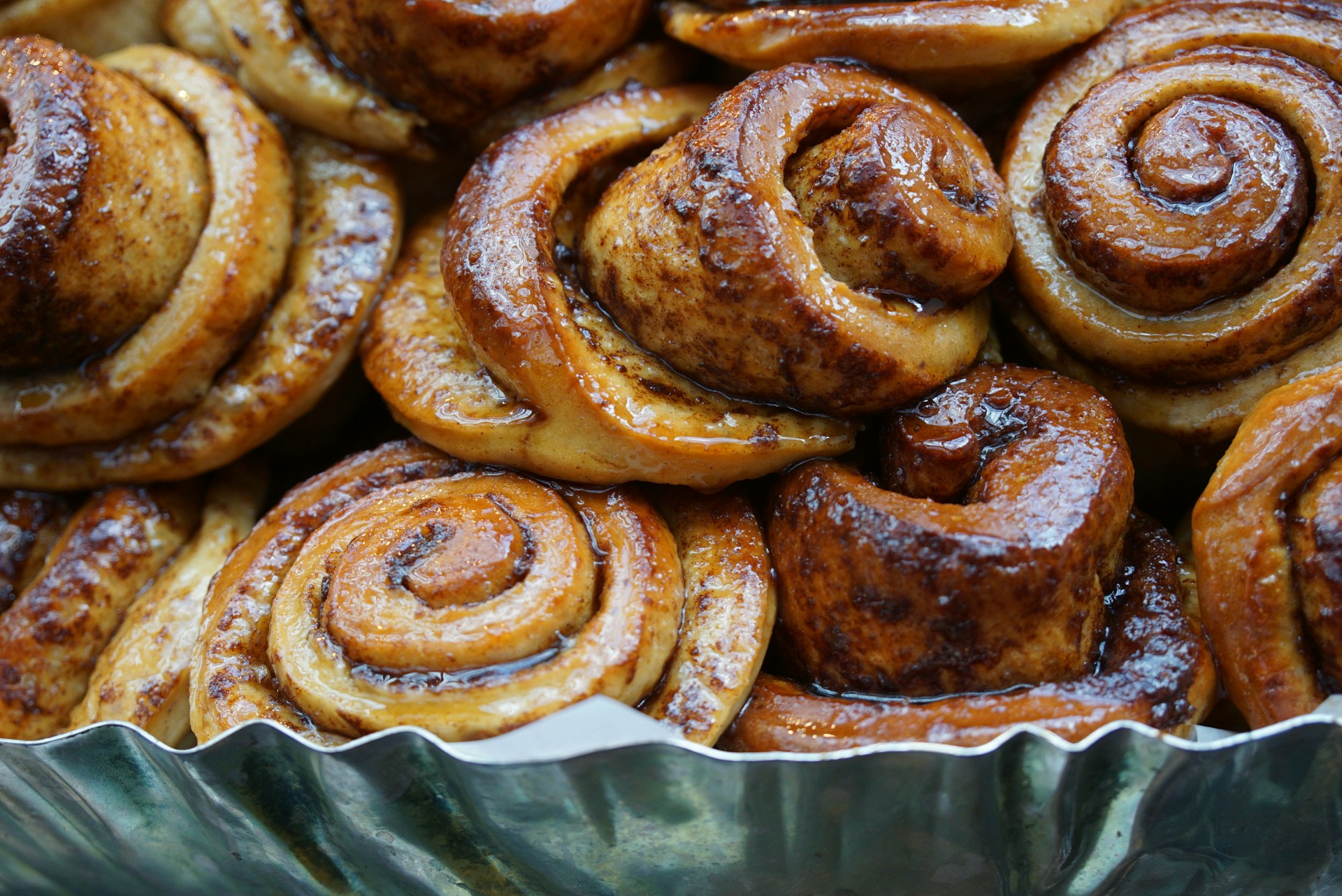 Sticky and sweet cinnamon rolls, fresh out of the oven, with swirls of cinnamon and a glossy glaze dripping down their sides.