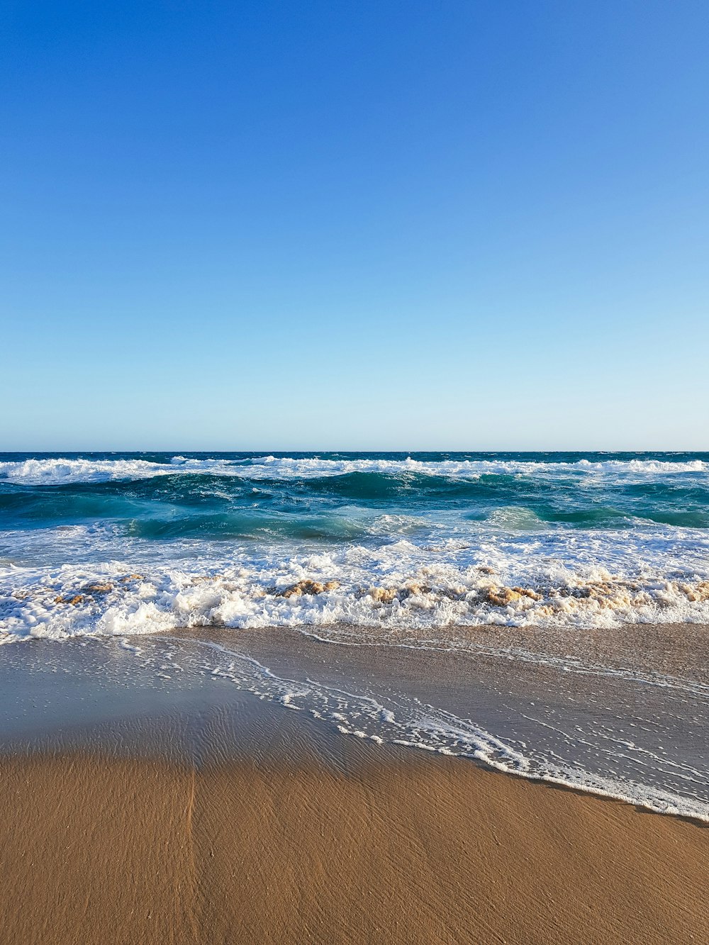 ocean waves crashing on shore during daytime