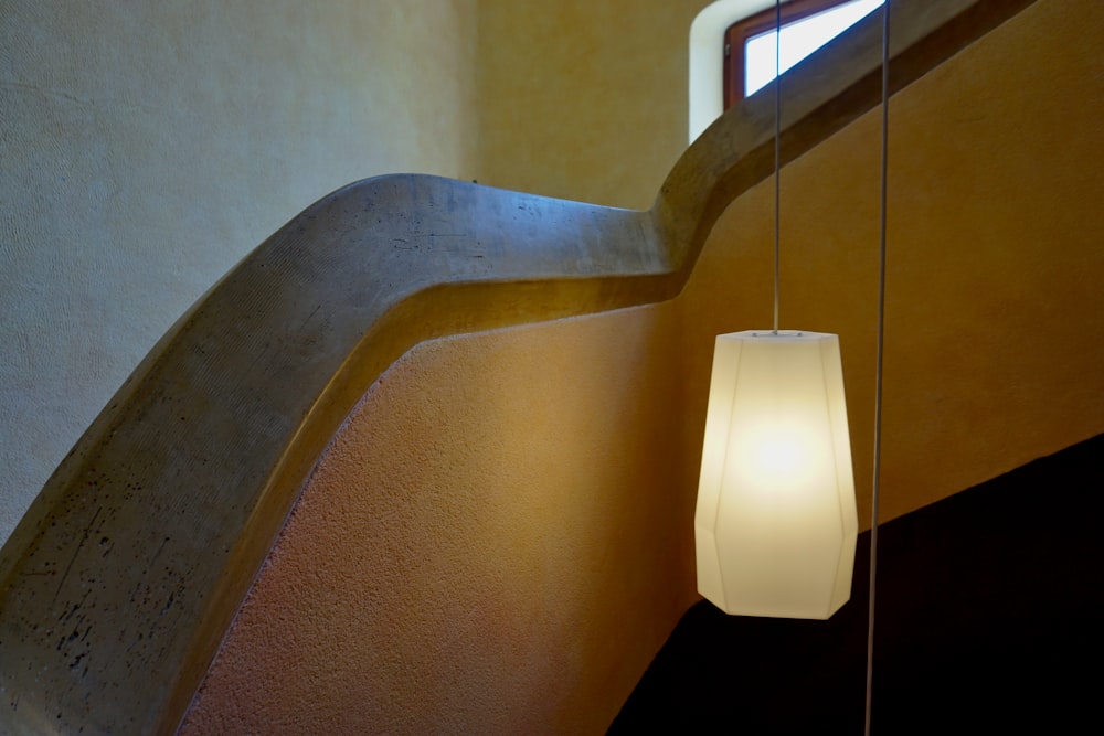 white pendant lamp turned on near brown wooden table