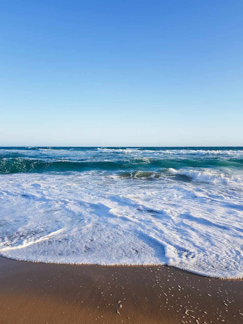 a beach with waves coming in and out of the water