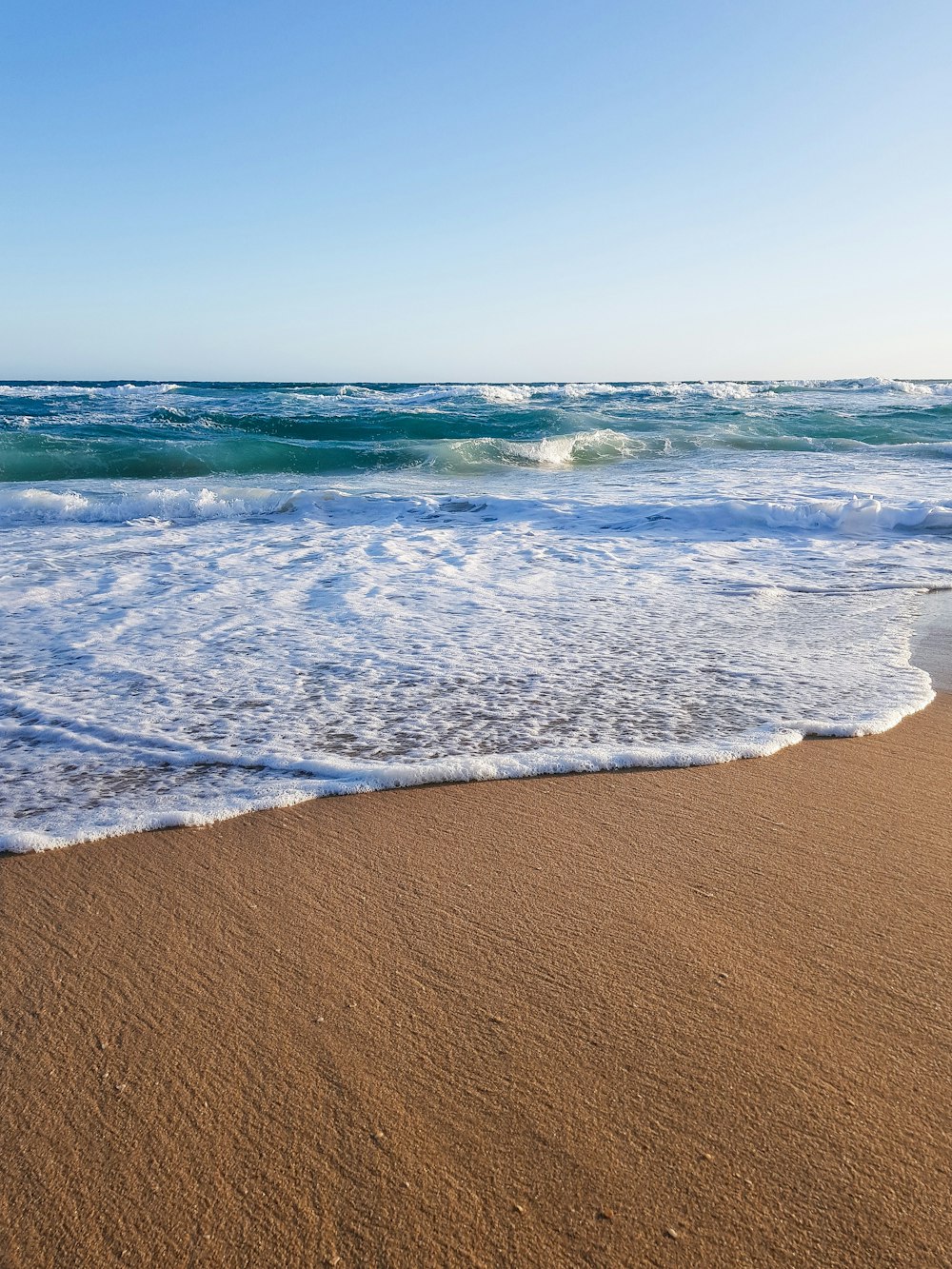 sea waves crashing on shore during daytime