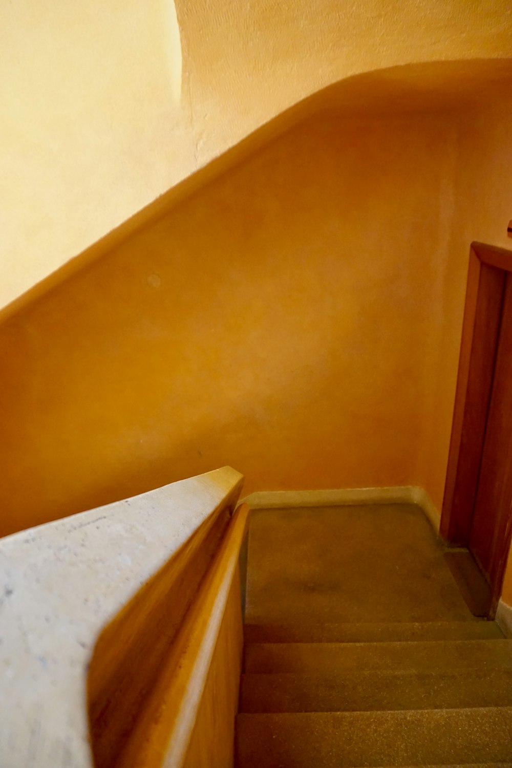 brown wooden door beside white wall