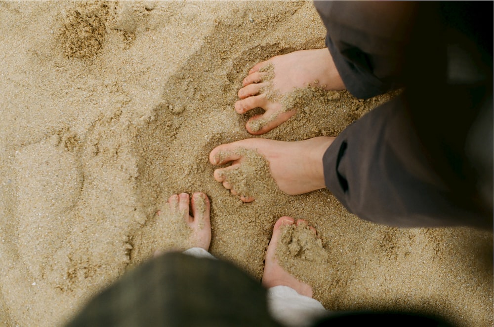 person in black pants standing on brown sand