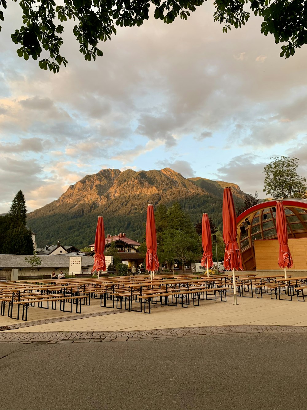 red and white metal frame near green mountain under white clouds during daytime