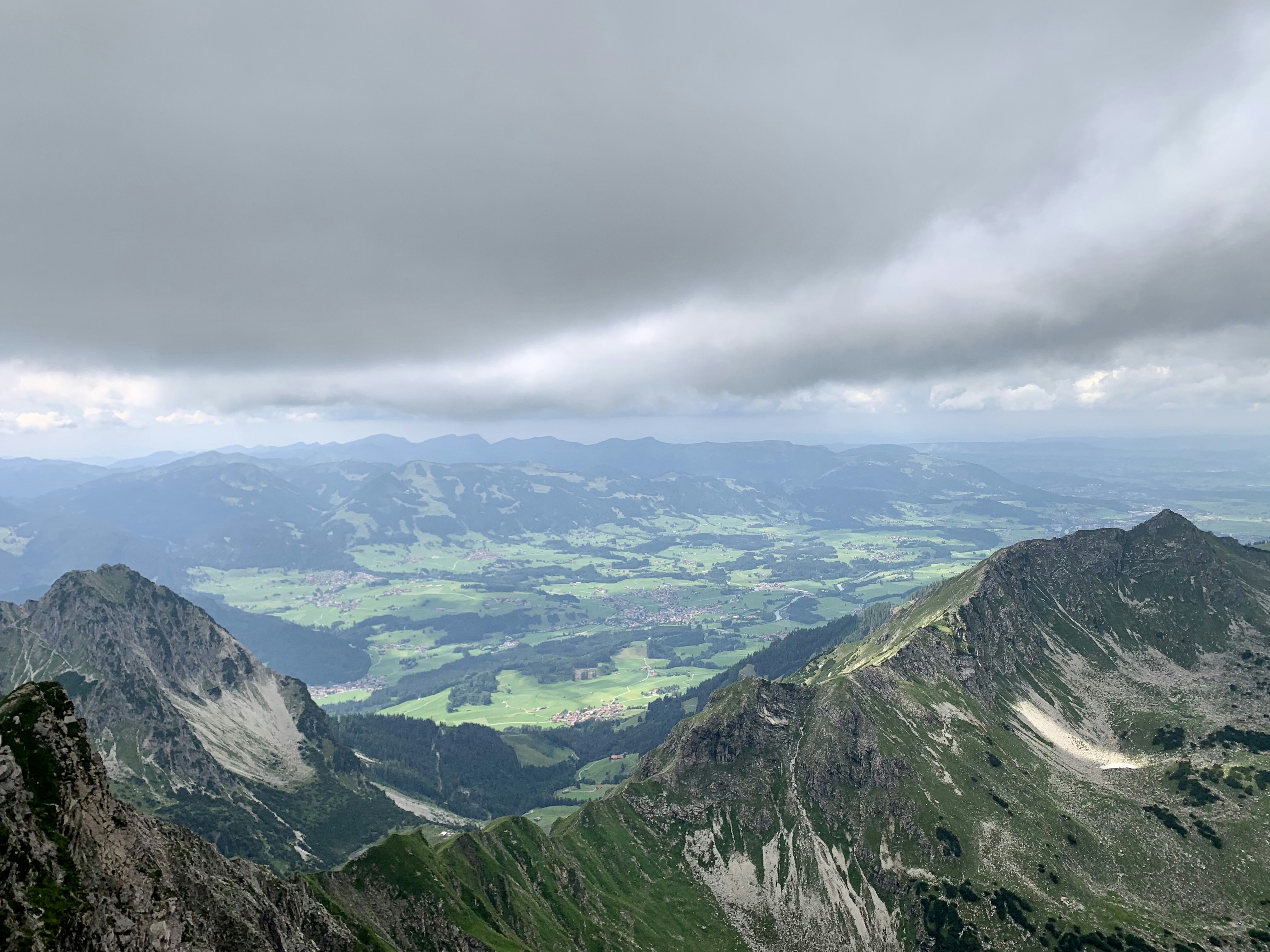 a view of the mountains from a high point of view, In the clouds, view from the summit of the Nebelhorn, 2224 m.</p><p>August 3, 2019