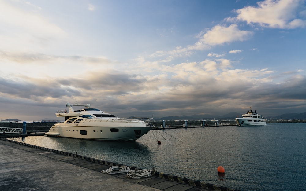 white yacht on sea dock under cloudy sky during daytime