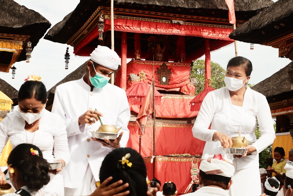 man in white thobe standing near red and white chinese temple during daytime