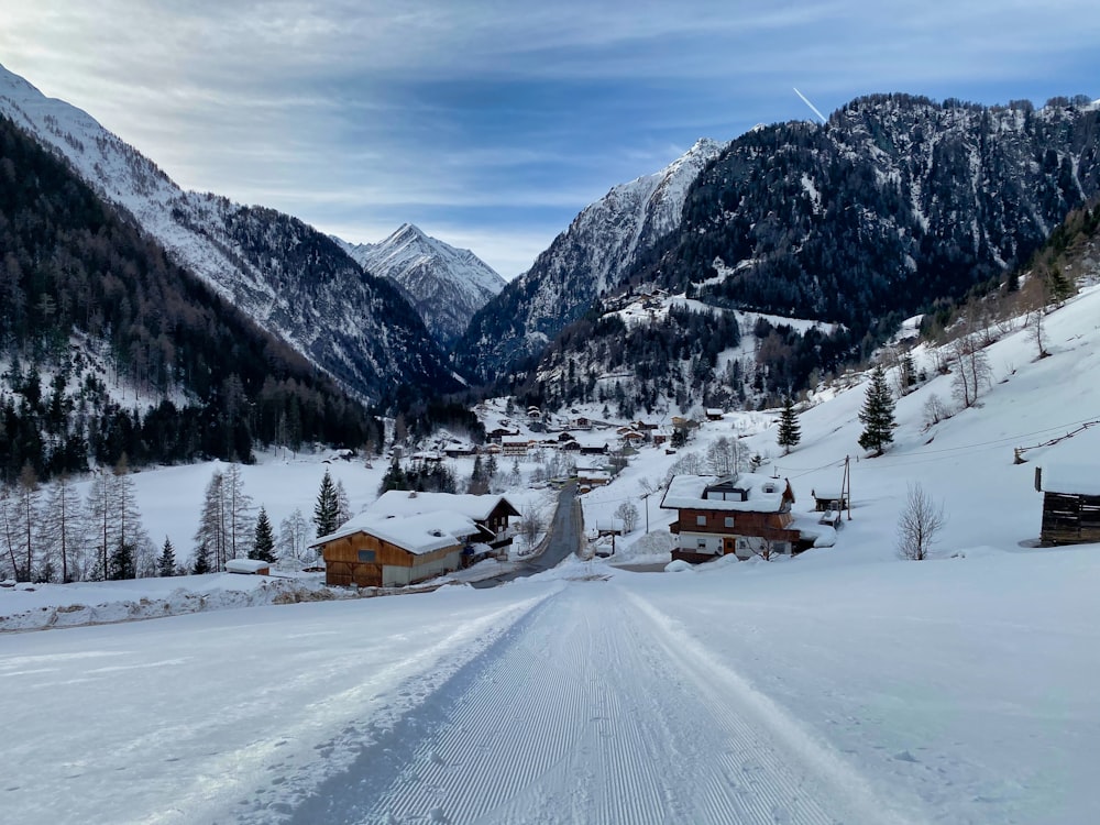 snow covered house near trees and mountains during daytime