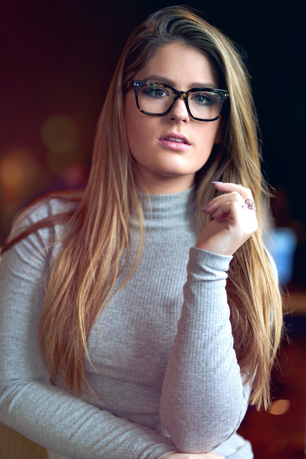 Frau im weißen Pullover mit schwarz gerahmter Brille