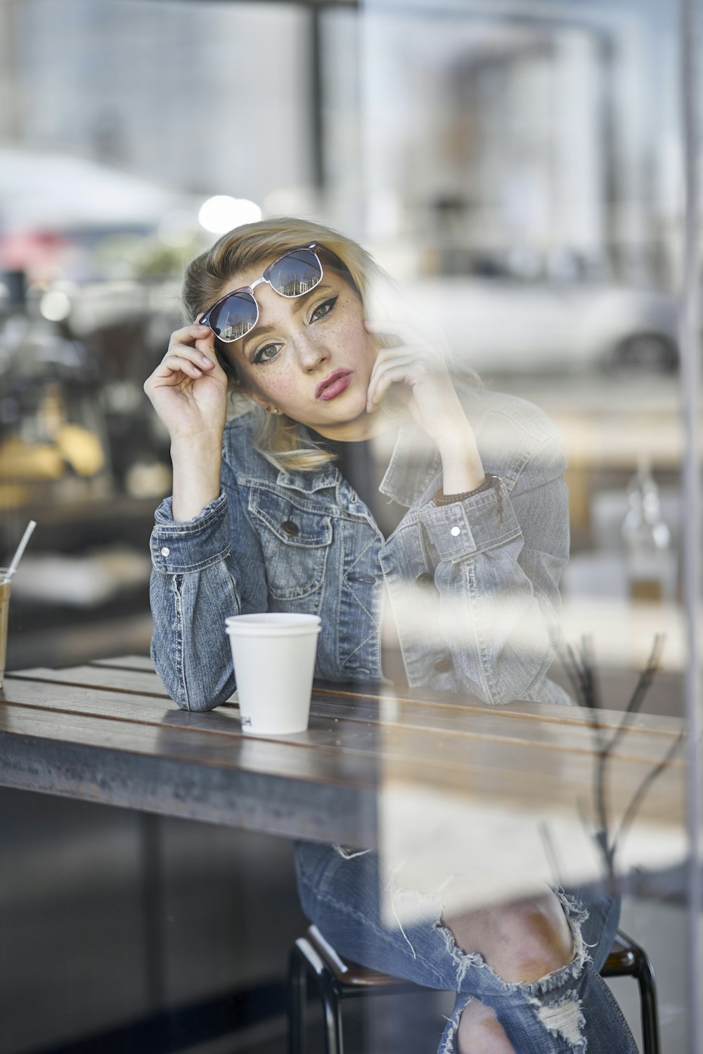 woman in blue denim jacket wearing black sunglasses