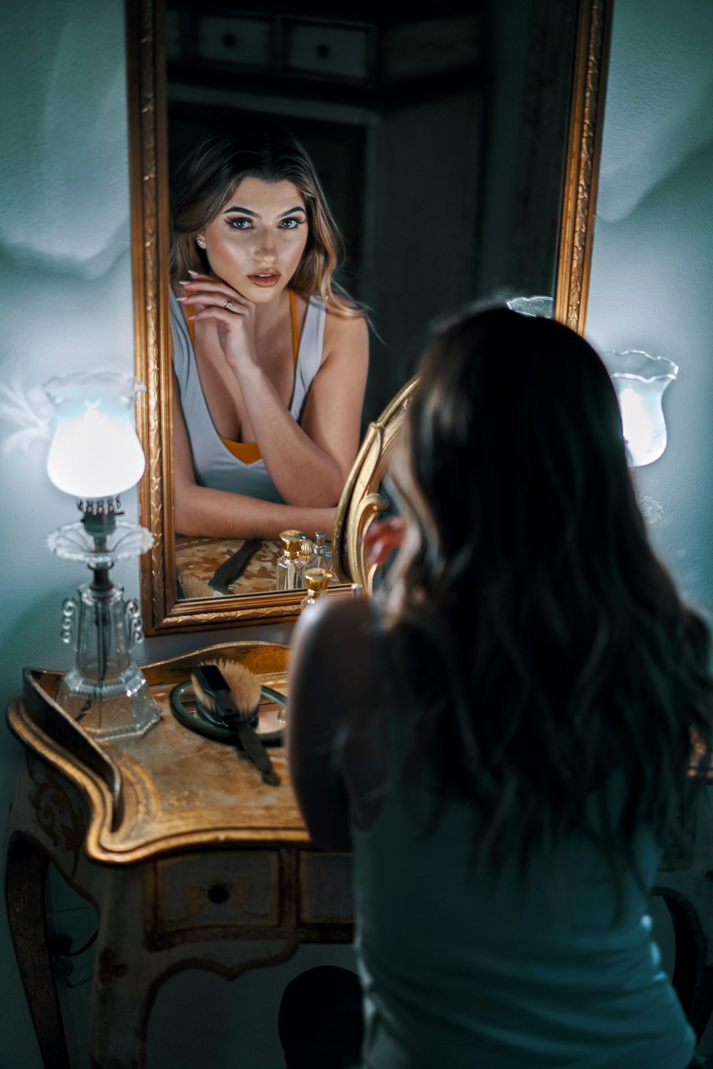 woman in black tank top standing beside mirror
