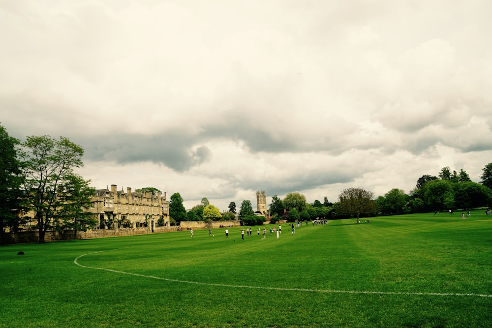 green grass field under cloudy sky during daytime