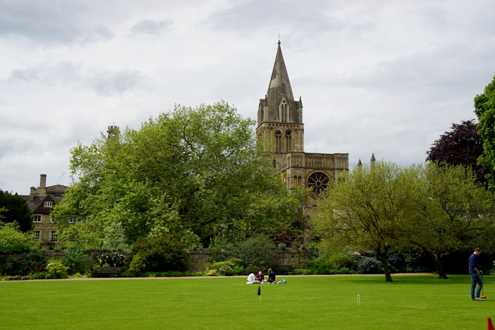 people walking on green grass field near brown concrete building during daytime