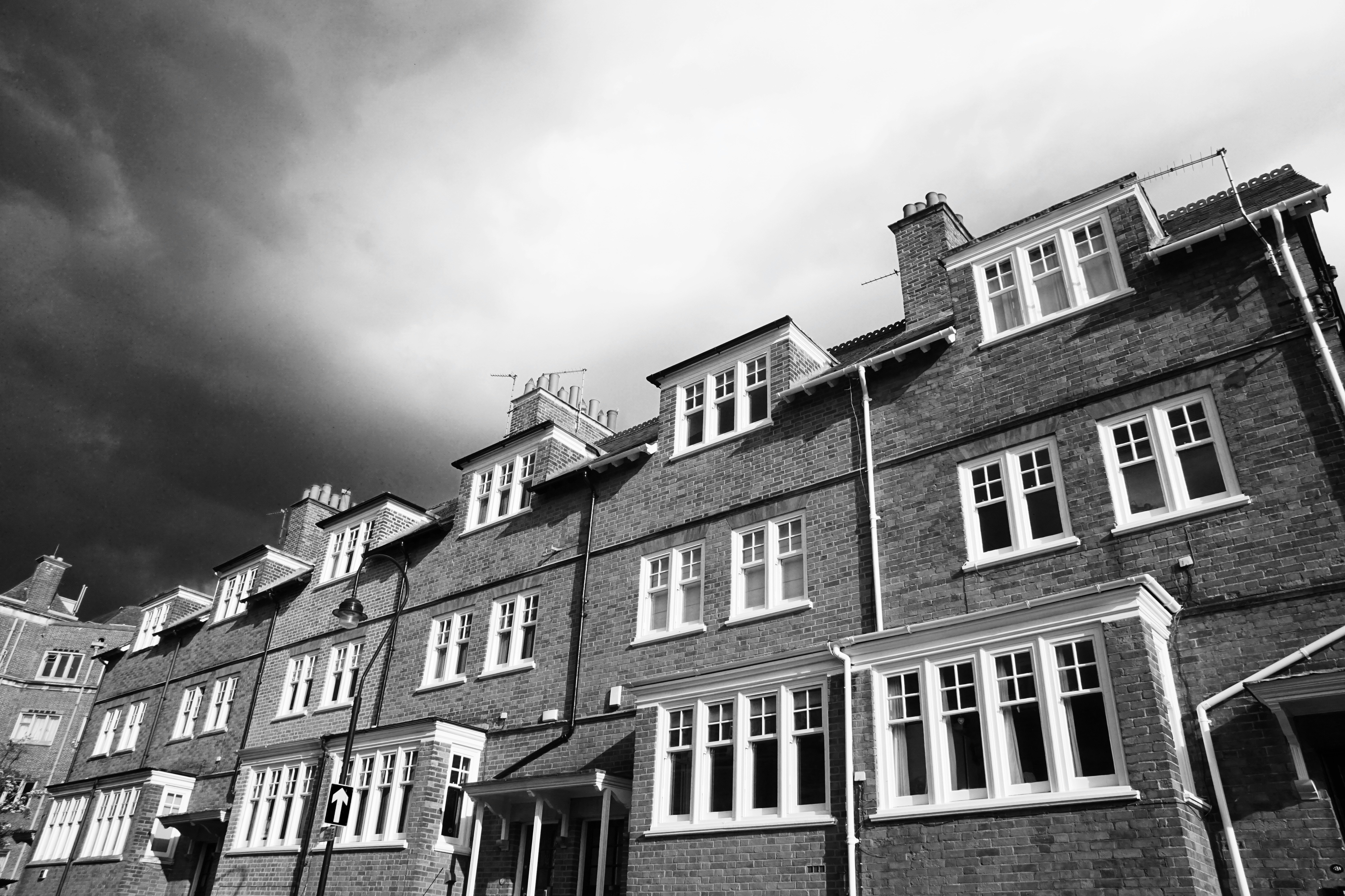Black and white of brick building with lots of white framed windows.