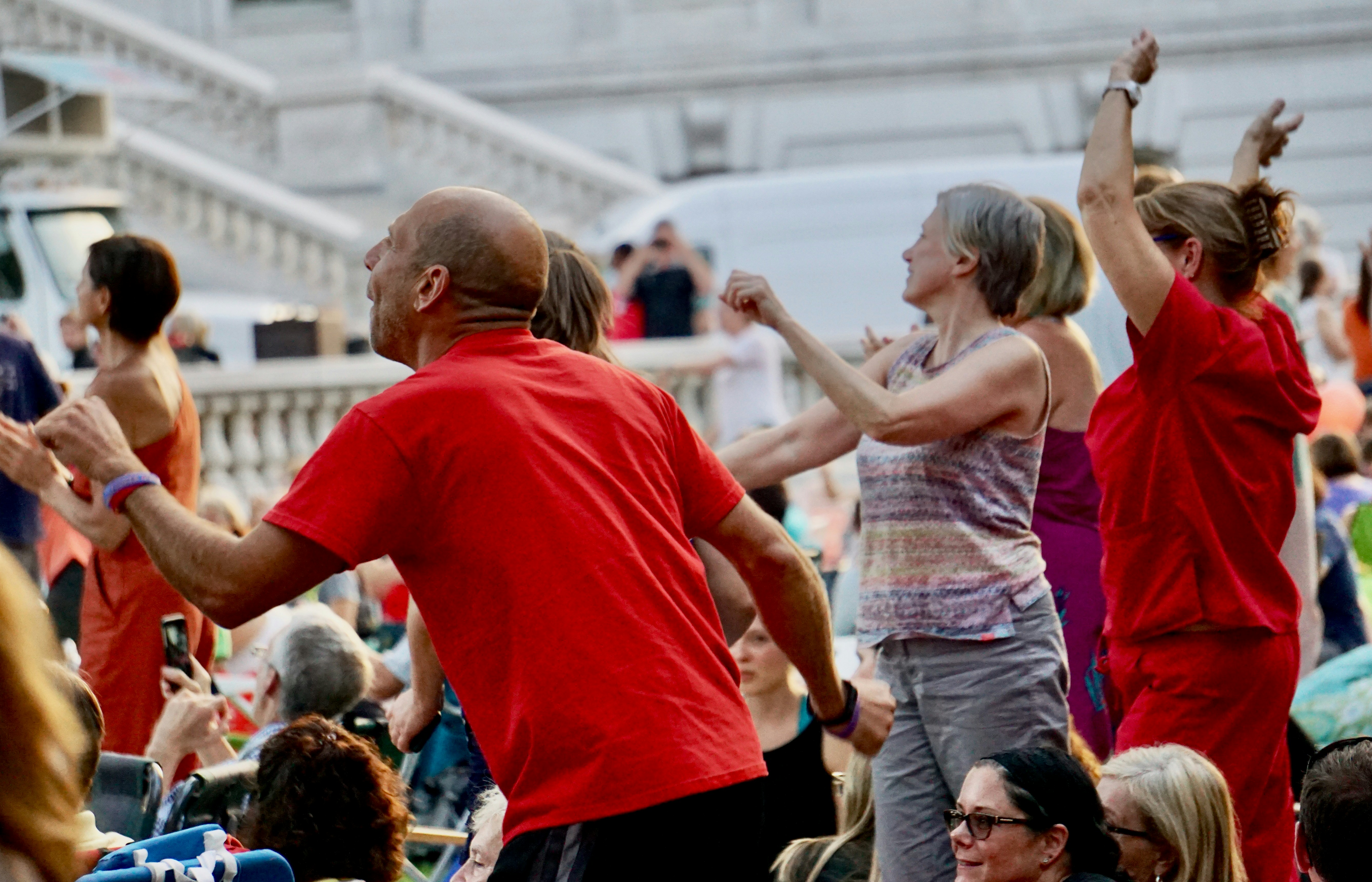 Mann im roten Rundhals-T-Shirt steht neben einer Frau in rosa Tanktop