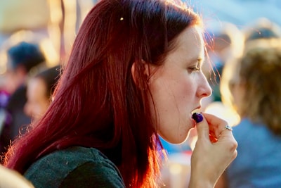 A cheerful person savoring a ragi snack while reading outdoors.