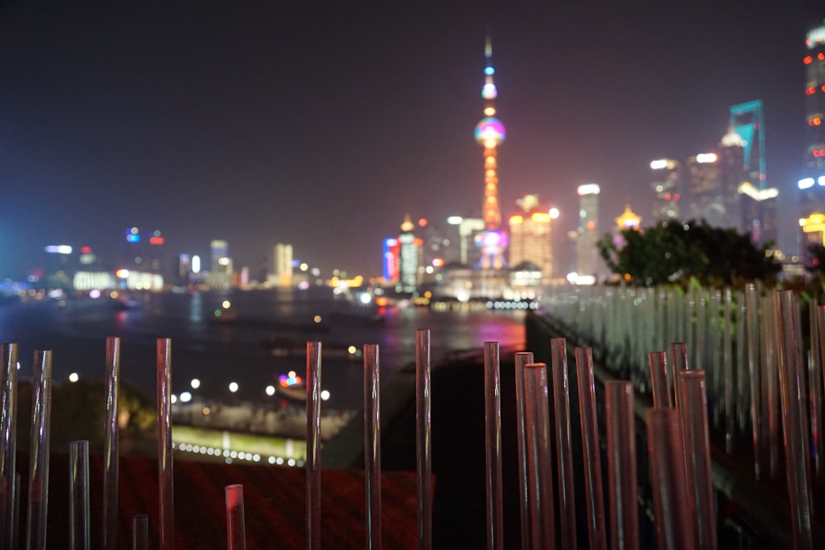 Shanghai Bund skyline at night with soft lavender and pink colors, showing the Pudong towers across the Huangpu River