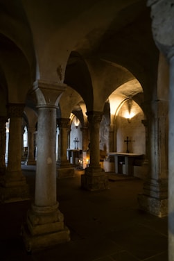 A mysterious ancient crypt illuminated by flickering torchlight, with hexagonal tiles scattered across a stone floor.