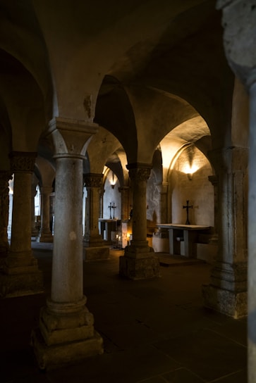A mysterious ancient crypt illuminated by flickering torchlight, with hexagonal tiles scattered across a stone floor.