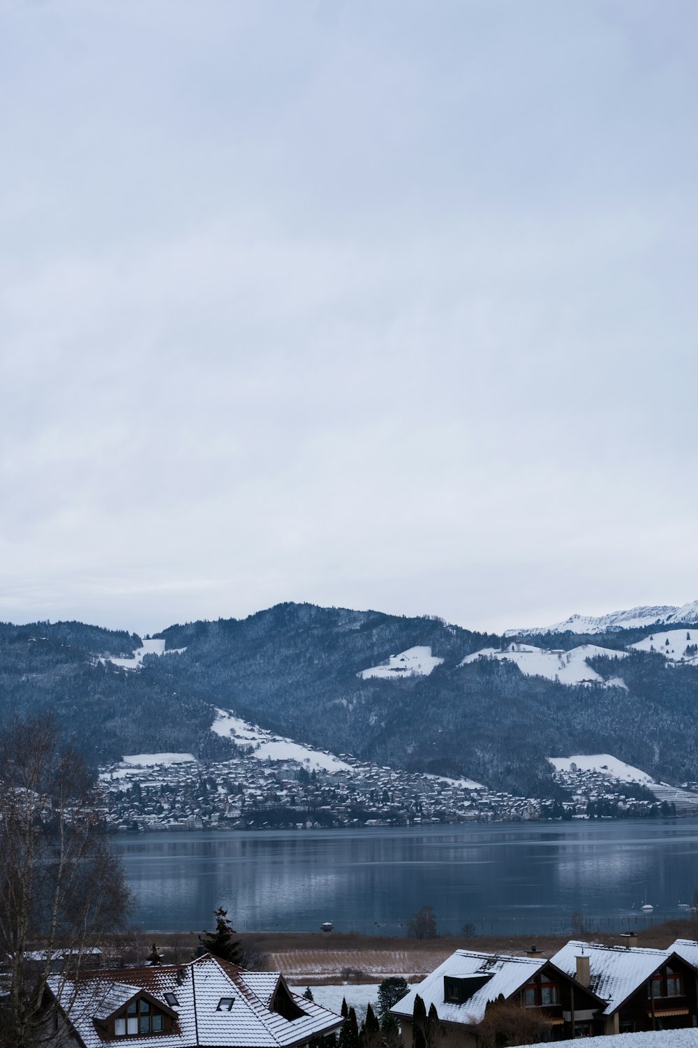 snow covered mountains near body of water during daytime