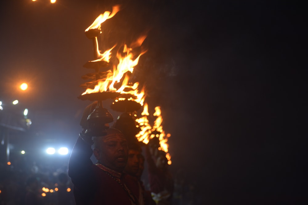 man in brown leather jacket holding fire