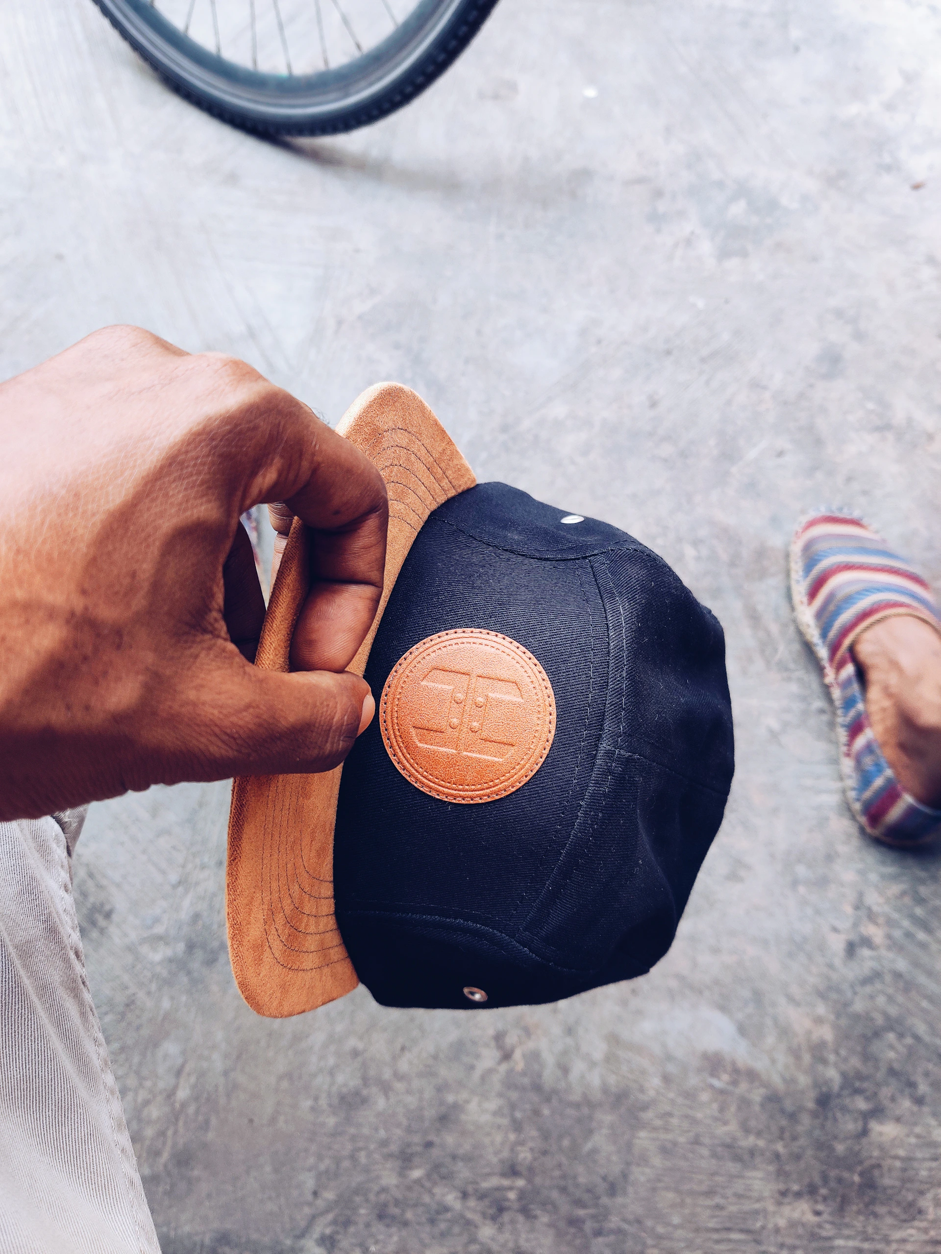 A sleek black cap with red stitching, resting on a graffiti-covered wall that echoes the urban vibe of the super elite brand.