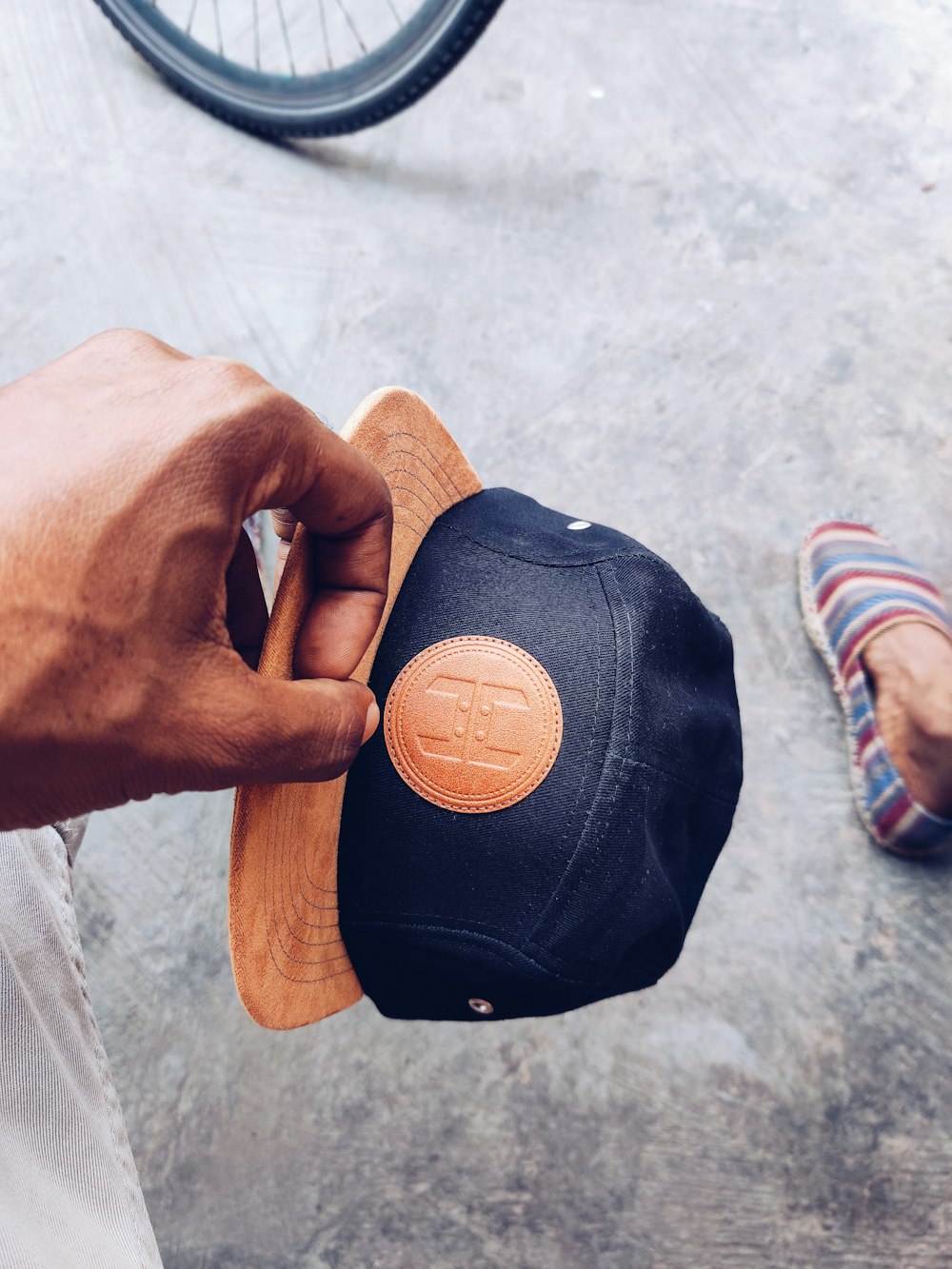 person holding black fitted cap