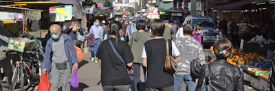Brayan Valentín speaking with local citizens in a bustling market in Peru, emphasizing safety and public health.