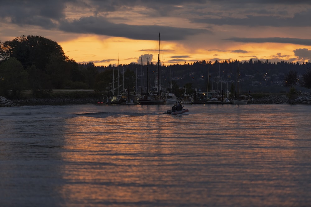 Silhouette d’arbres et de bateau sur l’eau au coucher du soleil