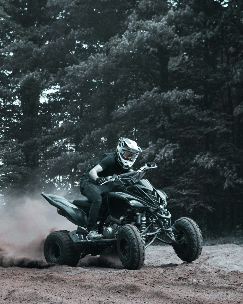 homem andando atv na estrada de terra